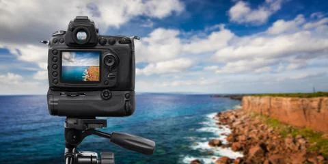 Reflex Camera on tripod over a cliff, performing a long exposure Stock Photos