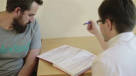 Reflexologist receives patient explaining him purpose of acupuncture points. Stock Footage 68964016