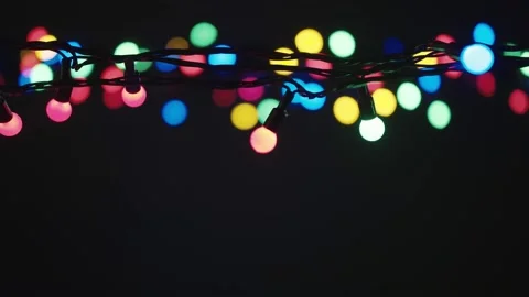 Refocus. Slowly Blinking garland lights in the dark Background with place for Stock Footage 144526403