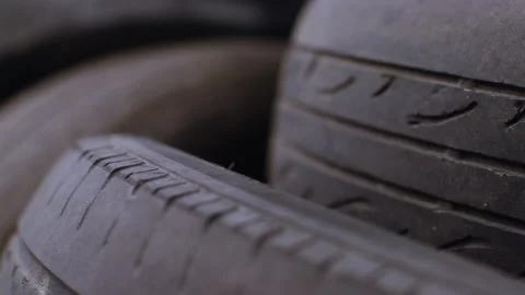 Refocus on two tires that lie on top of each other in a mountain of black tires 库存影片 256064721
