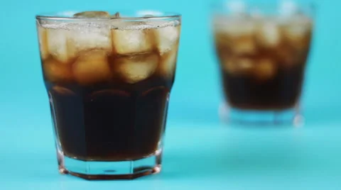 Refocusing glass of cola on a blue background Stock Footage 62603257