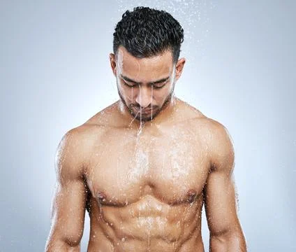 Refresh your senses. Studio shot of a handsome young man taking a shower against Stock Photos