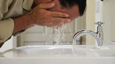 Refreshing after hot tropical day, tourist man rinse face by cold water, slowmo Stock Footage 153710968