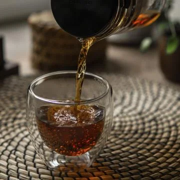 A refreshing and invigorating glass of iced tea is being poured, surrounded by a Stock Photos