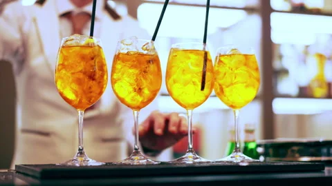 Refreshing Aperol Spritz cocktail glasses with black drinking straws at the bar Stock Footage 345158309