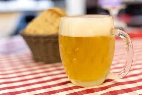 Refreshing beer served with bread in a cozy dining setting during an evening Stock Photos