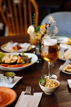 Refreshing beer served on table with delicious dishes Stock Photos
