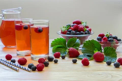 Refreshing berry drinks with assorted fruits arranged on a wooden table Stock Photos