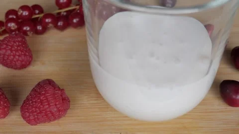 Refreshing Berry Milkshake with Fresh Raspberries on Rustic Wooden Board Stock Footage 334582264