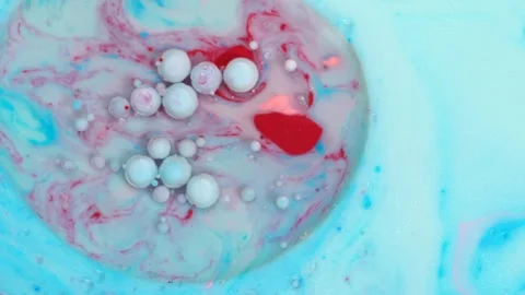 A refreshing blend of shiny blue, white and red ink swirls with bubbles cre.. Stock Footage 273675772