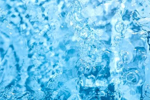 Refreshing blue water surface with bubbles and ripples, clean liquid movement Stock Photos