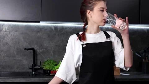 Refreshing break in a modern kitchen with a glass of water Stock-Footage 296319052