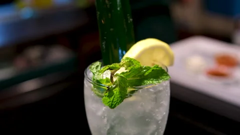 Refreshing cocktail garnish sequence of pouring blue cocktail into a glass with Stock Footage 313529088