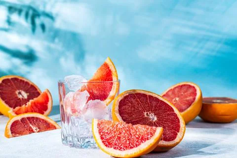 Refreshing cocktail with grapefruit on a blue background. a glass glass with  Stock Photos