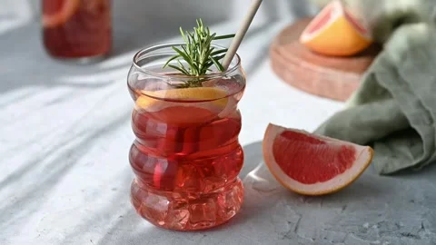 Refreshing cocktail with grapefruit, rosemary and ice in glass on table with Stock Footage 314617866