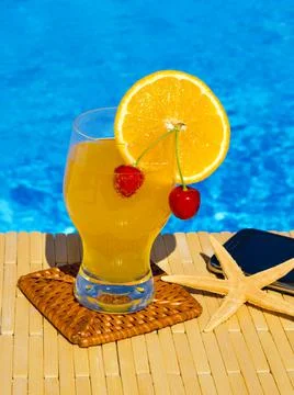A refreshing cocktail, juice with a red cherry and an orange inside, next to  Stock Photos