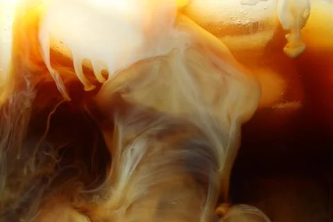 Refreshing coffee with ice and milk as background, closeup Foto stock