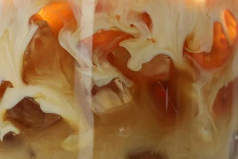 Refreshing coffee with ice and milk as background, closeup 写真素材