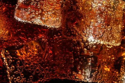 Refreshing cola with ice as background, macro view Stock Photos