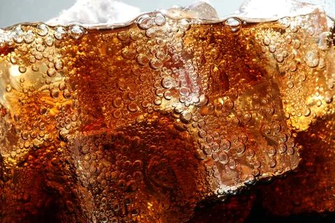 Refreshing cola with ice as background, macro view Stock Photos