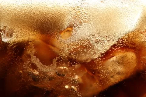 Refreshing cola with ice as background, macro view Stock Photos