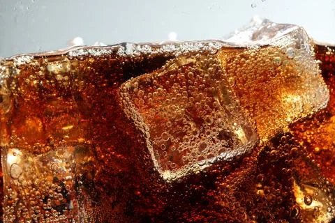 Refreshing cola with ice cubes against light grey background, closeup Foto stock