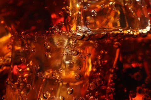 Refreshing cola with ice cubes as background, macro view 写真素材