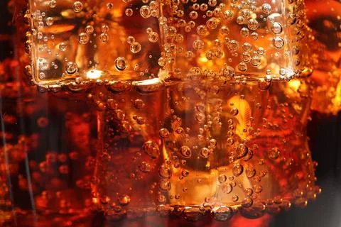 Refreshing cola with ice cubes as background, macro view Foto stock