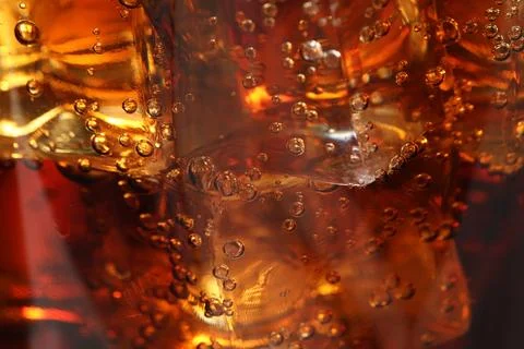 Refreshing cola with ice cubes as background, macro view Stock Photos