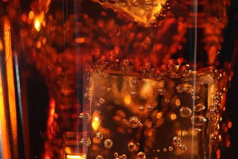 Refreshing cola with ice cubes as background, macro view 写真素材