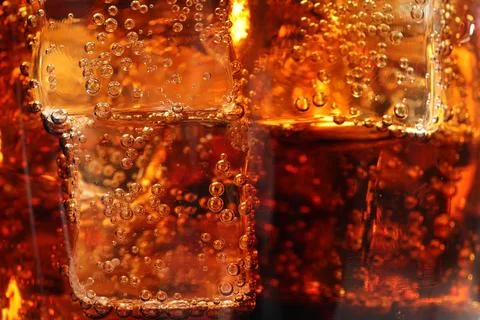 Refreshing cola with ice cubes as background, macro view 写真素材