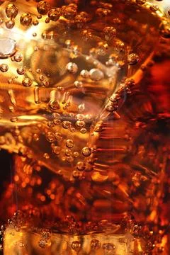 Refreshing cola with ice cubes as background, macro view 写真素材