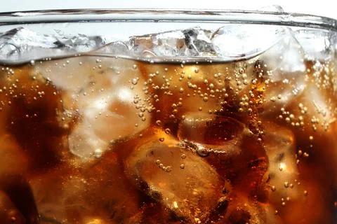 Refreshing cola with ice in glass, macro view Stock Photos