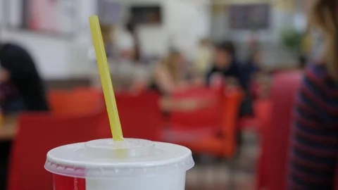 Refreshing cola plastic cup on a table with people blurred in the background. Stock Footage 81564889
