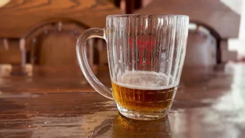 A Refreshing Cold Beer in a Mug Sitting on a Rustic Wooden Table Perfect for Stock Footage 316403117