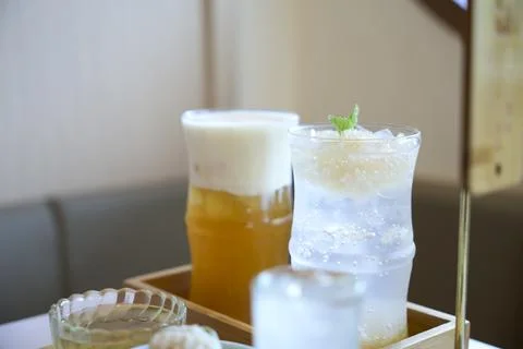 Refreshing cold beverages with ice and mint on table in cafe Stock Photos