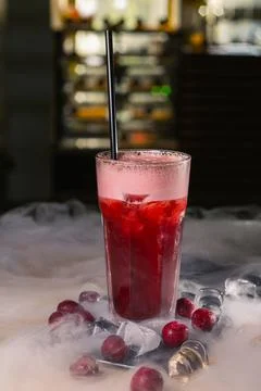 Refreshing cold cherry cocktail with straw placed on table 스톡 사진