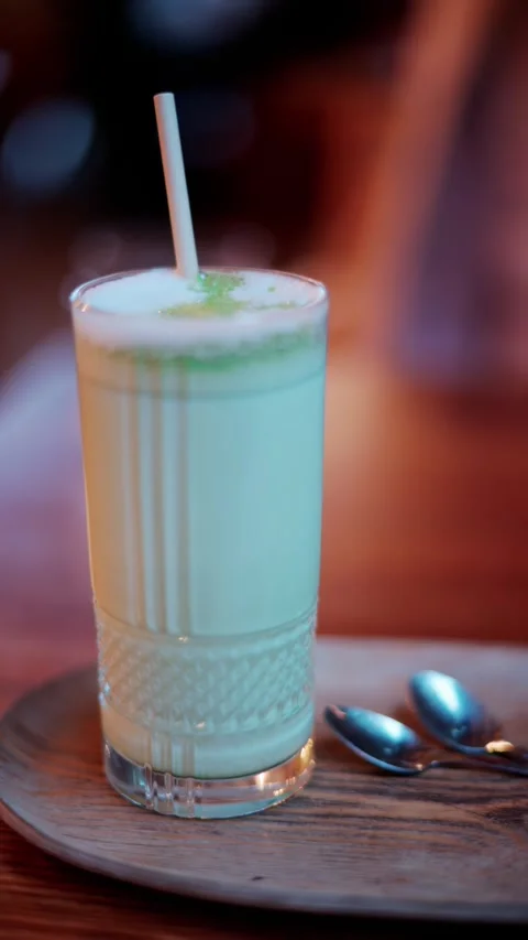 Refreshing cold drink with ice and lime in a tall glass with straw on woode.. Stock Footage 339652764