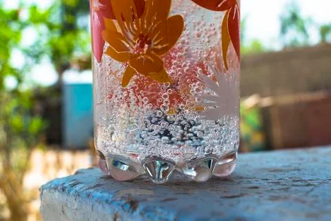 Refreshing cold drink producing bubbles in a glass with blurred background. Stock Photos