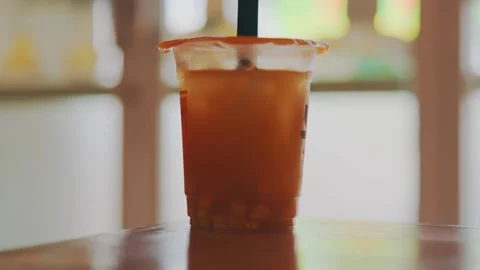 Refreshing Cold Iced Tea or Fruit Drink in Plastic Cup with Toppings on Table Video stock 333321926