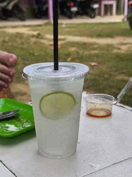 Refreshing Cold Lime Drink with Condensation on an Outdoor Table 스톡 사진