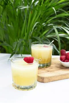 Refreshing cold melon drink with ice and lime slices, garnished with raspberries Foto stock