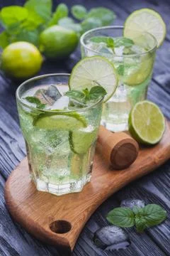 Refreshing cold mojito with ice on a black wooden table Stock Photos