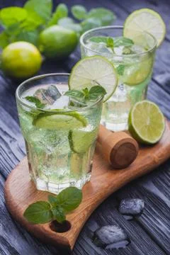 Refreshing cold mojito with ice on a black wooden table Stock Photos