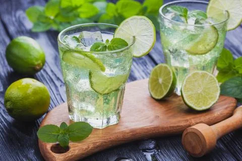 Refreshing cold mojito with ice on a black wooden table Stock Photos