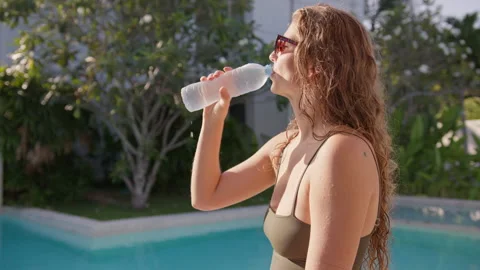 Refreshing cold water moment by the pool during a sunny day. The warm weather Stock Footage 296717766