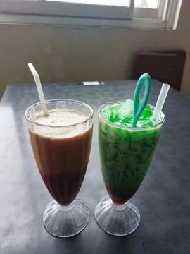 A refreshing combination of Es Cendol and Cappuccino drinks Stock Photos