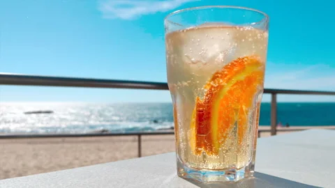 Refreshing cool drink at beach on a sunny summer day with blue sky Stock Footage 130591725