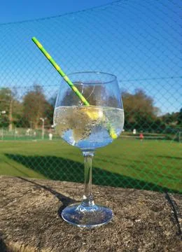 Refreshing cool drink standing on wall with tennis courts behind Stock Photos