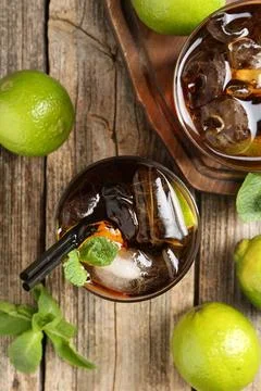 Refreshing Cuba libre cocktail with mint on wooden table, flat lay 스톡 사진